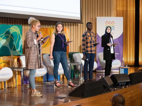 Four Scouts speak on stage during the World Non-Formal Education Forum