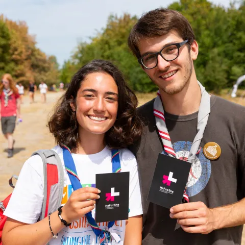 Two Scouts, a boy and a girl, stand together holding a HeForShe sign for gender equality
