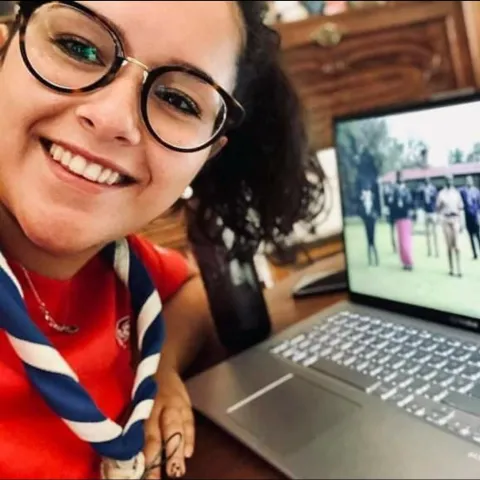 Portugal Scout smiles next to a laptop
